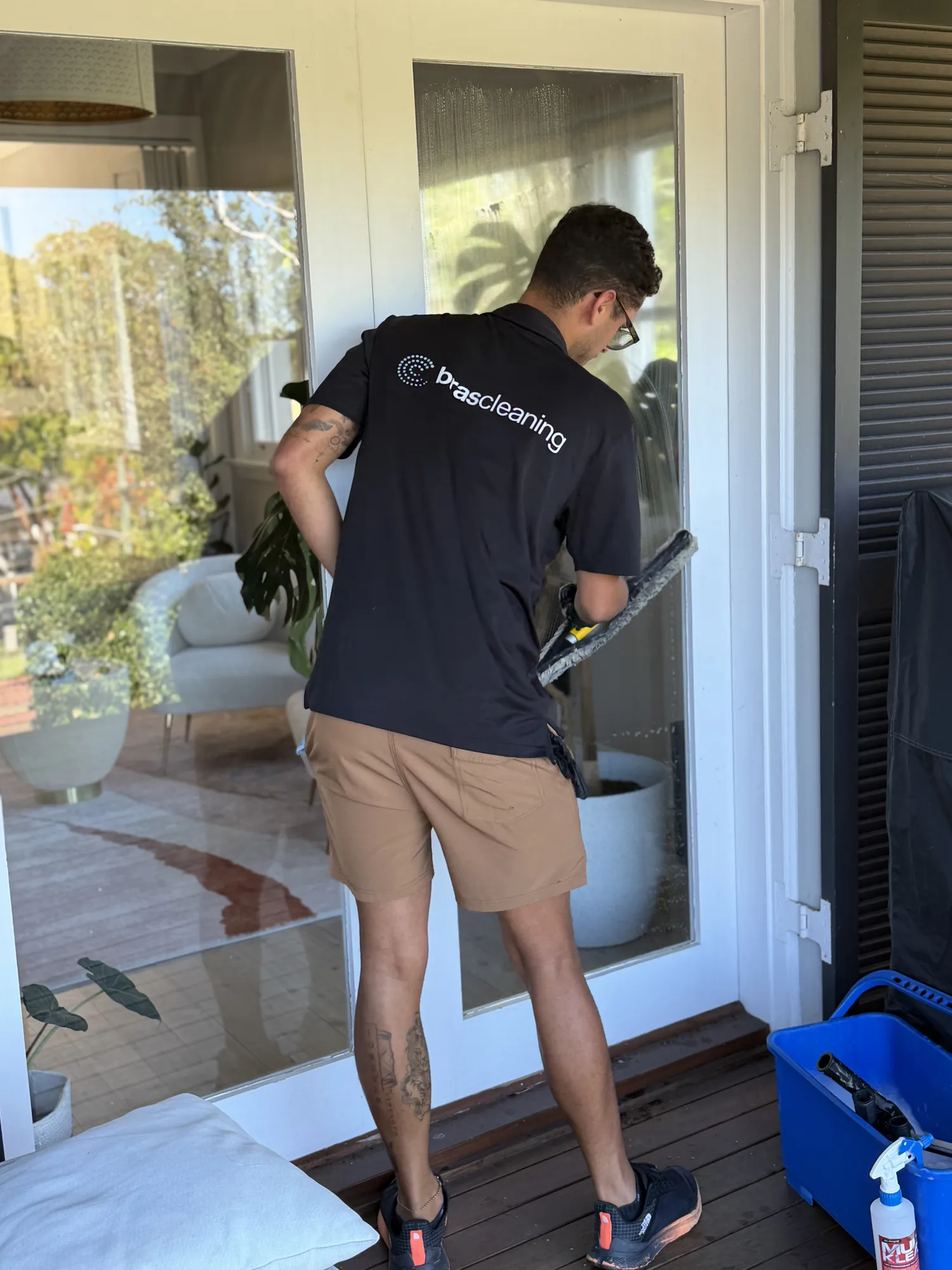 Brascleaning co-founder André da Silva cleaning a glass door in a Northern Beaches home